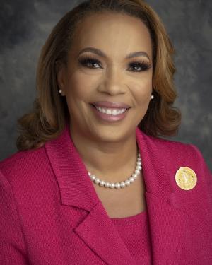 Headshot of Nadine Vargas Stewart wearing a pearl necklace and pink blazer