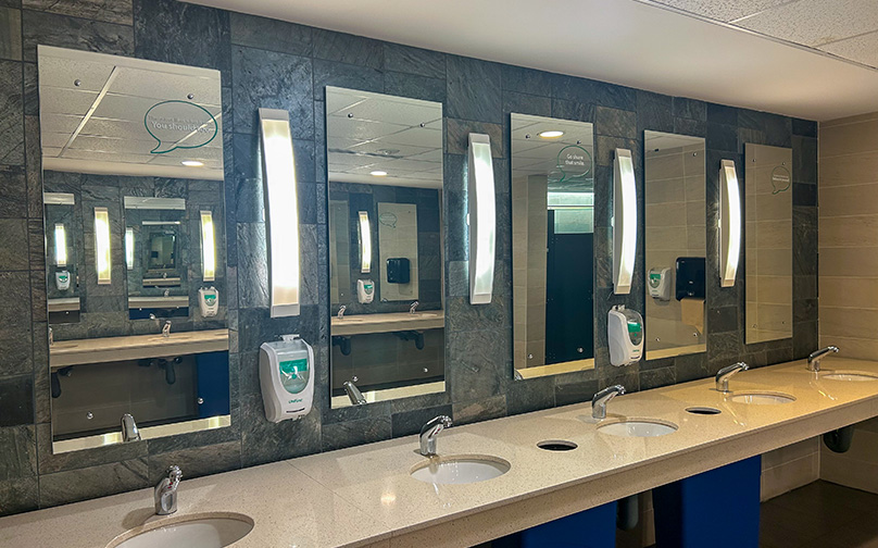 Bathroom mirrors with speech bubble decals containing motivational phrases.